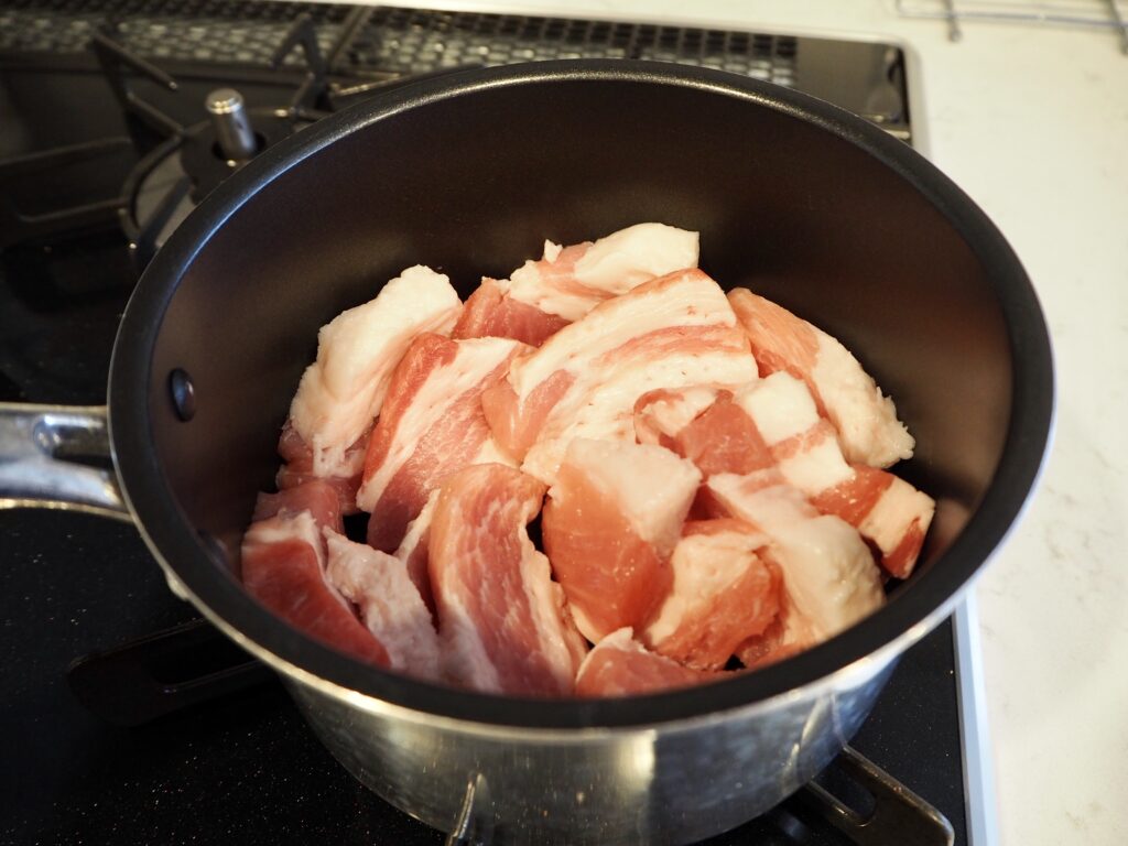 豚バラ肉を鍋に入れる